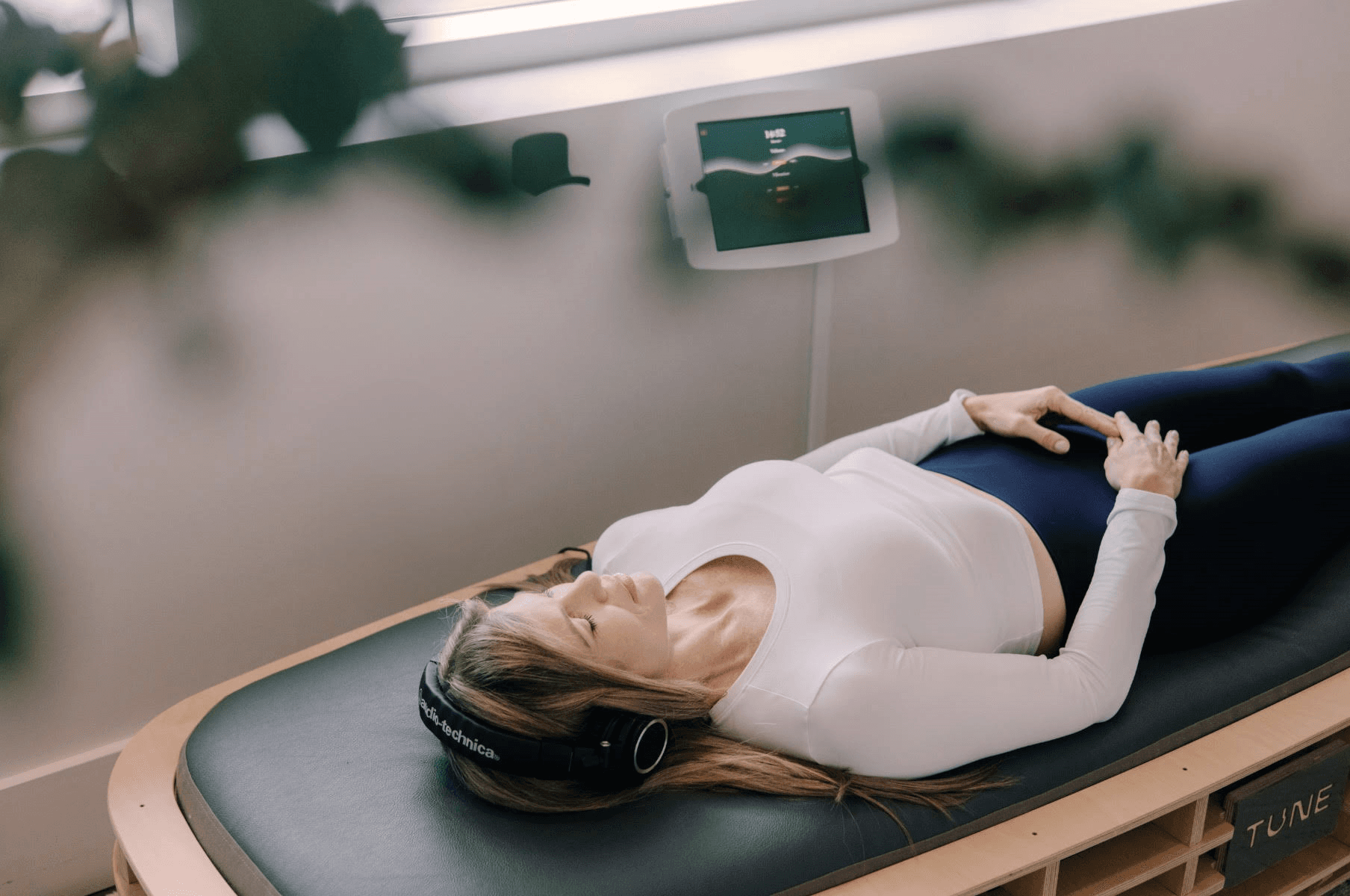 Woman lying down with eyes closed and hands on chest.